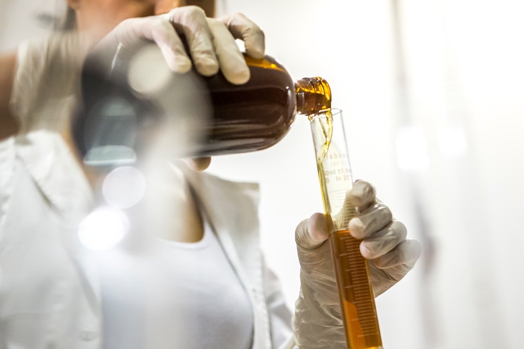 woman wearing white lab coat holding brown bottle and glass tube of Endoca